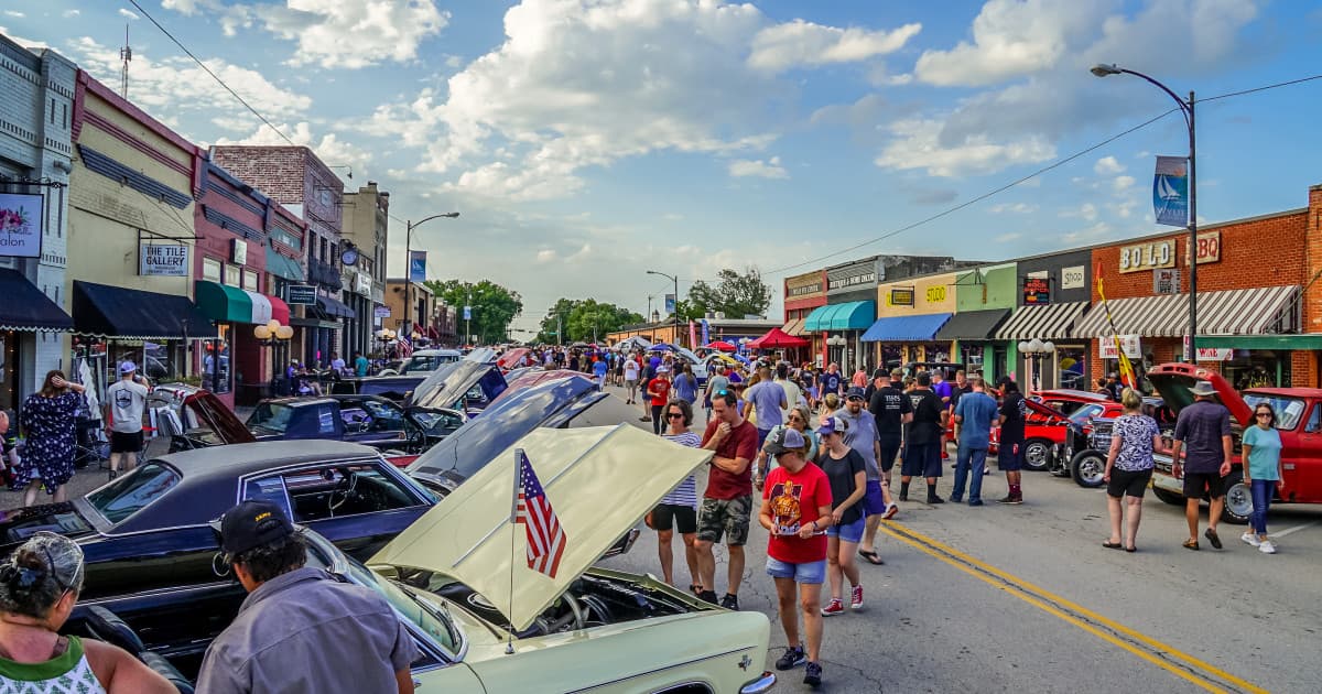 Crowd lining classic cars on a sunny day along historic downtown Wylie, Texas during a community car show